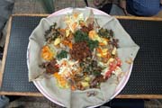 Tradi�n� a jedin� j�dlo - injara, kysel� placka vzhledov� se bl��c� pala�ince. Pod�v� se s r�zn�m mixem masa a zeleniny. Jih, Etiopie.